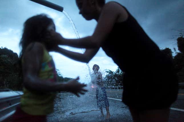 A family bathe with mountain spring water after hurricane Maria hit Puerto Rico