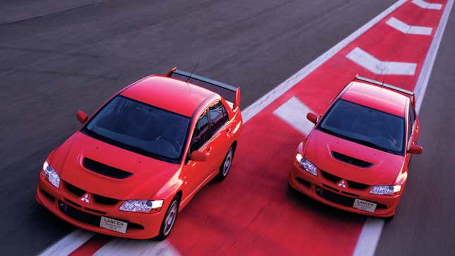 A photo of two Mitsubishi Lancer Evolution VIII cars on track. 