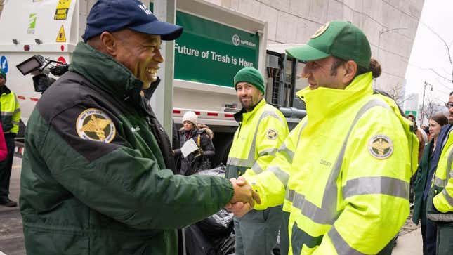 Mayor Eric Adams shaking hands with a Sanitation Department employee