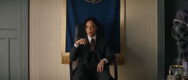 Tessa Thompson as King Valkyrie in a suit, sitting down and looking annoyed