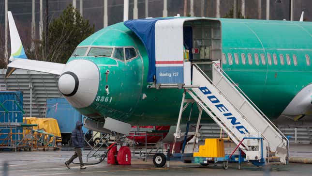 A person walks past an unpainted Boeing 737-8 MAX parked at Renton Municipal Airport adjacent to Boeing's factory in Renton, Washington on January 25, 2024. 