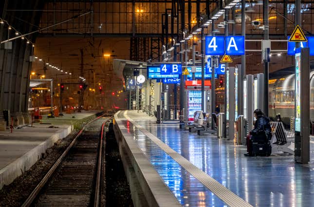 A woman sits on an empty platform in the central train station in Frankfurt, Germany, Friday, Dec. 8, 2023, when train drivers of the GDL union went on a 24-hour-strike. (AP Photo/Michael Probst)