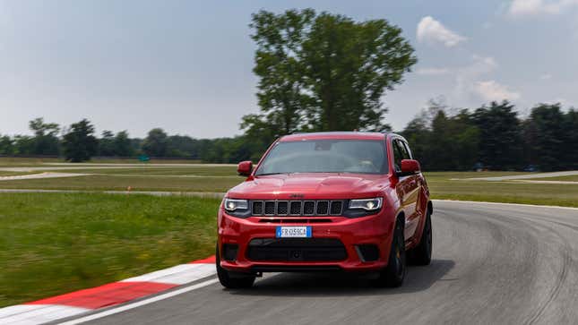 A photo of a red eep driving on a track. 