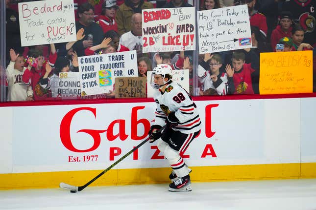 Chicago Blackhawks center Connor Bedard (98) warms up for the team&#39;s NHL hockey game against the Ottawa Senators, as fans hold signs Thursday, March 28, 2024, in Ottawa, Ontario. (Sean Kilpatrick/The Canadian Press via AP)