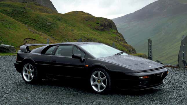 A photo of a black Lotus Esprit sports car parked in a rural spot. 