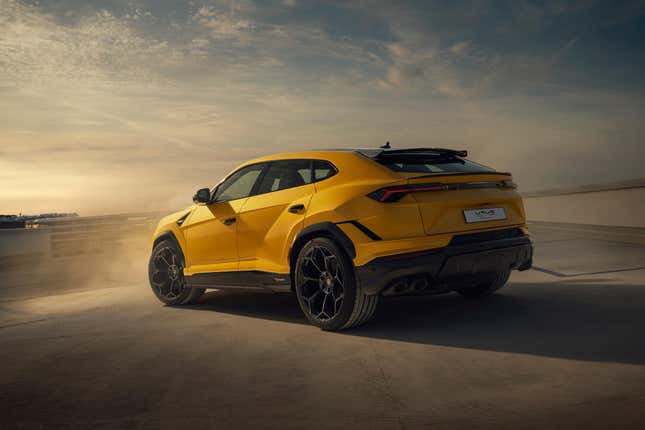 A yellow Lamborghini Urus Performante parked in a dusty parking lot.