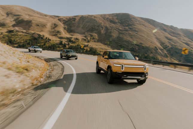 three Rivian R1Ts driving in a line on a mountain road 