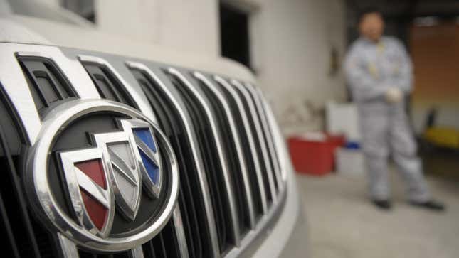 A mechanic looks at a Buick at a General Motors (GM) dealership in Shanghai on December 6, 2011.