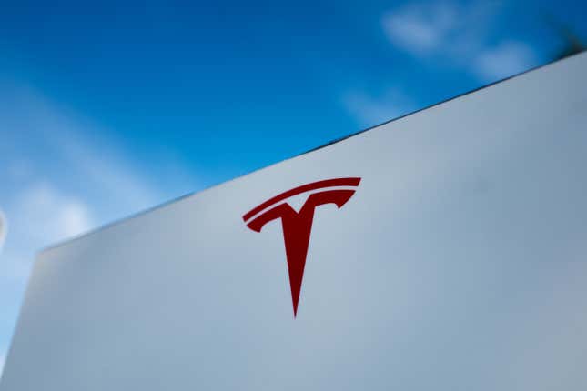 Close-up of Tesla Motors logo against a bright blue sky in Pleasanton, California.