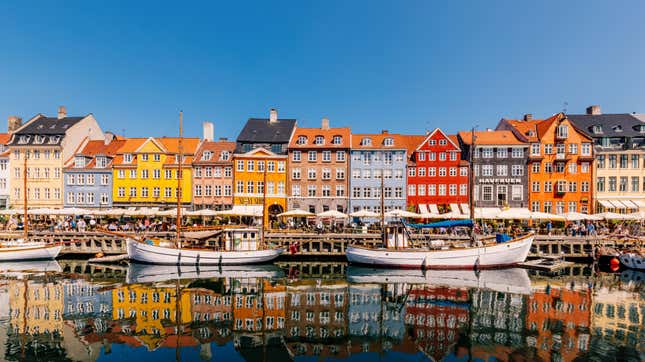 colorful houses line a canal of water with boats