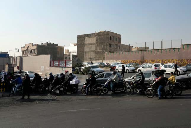 Motorcycles and cars line up outside a gas station in Tehran, Iran, Monday, Dec. 18, 2023. Nearly 70% of Iran&#39;s gas stations went out of service on Monday following possible sabotage — a reference to cyberattacks, Iranian state TV reported. (AP Photo/Vahid Salemi)