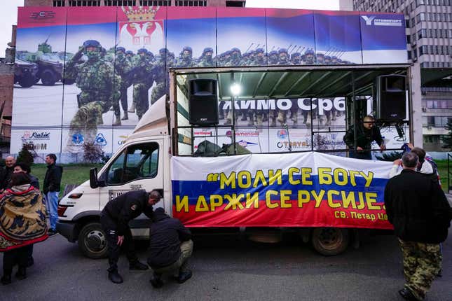 People set on a truck a Russian flag, that reads: &quot;Pray to God, hold on to Russia&quot;, prior to a rally in front of the former Serbian army headquarters, destroyed during NATO&#39;s bombing campaign, in Belgrade, Serbia, Sunday, March 24, 2024. Serbia marks the 25th anniversary of the beginning of the NATO air-campaign in 1999, on Sunday. (AP Photo/Darko Vojinovic)