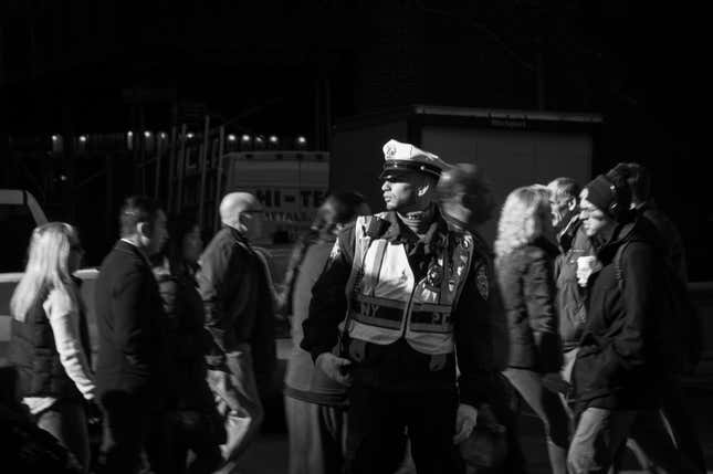 A police officer watches pedestrians in midtown Manhattan.