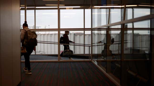 Travelers board plane at Dallas Fort Worth International Airport