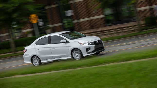 A white Mitusbishi Mirage G4 sedan driving in a city