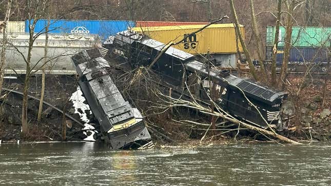 Two Norfolk Southern locomotives sitting on a river embankment