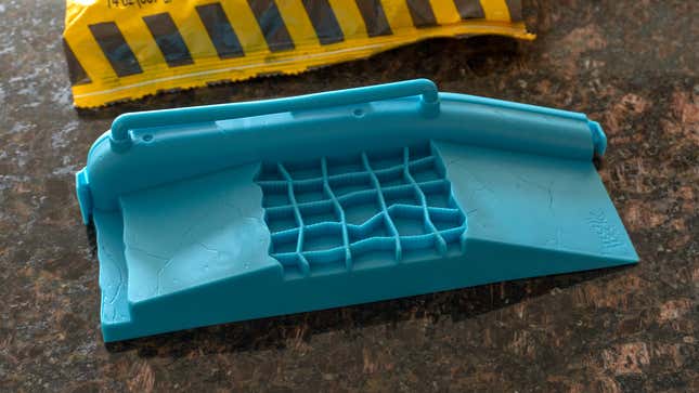 A blue plastic mold featuring a ramp and a rail for grinding.