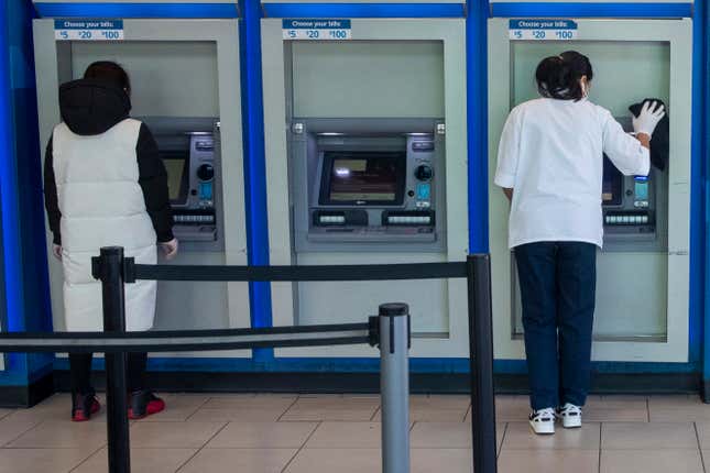 FILE - A customer makes a transaction at a bank of automatic teller machines in the Queens borough of New York on March 24, 2020. The cost to overdraw a bank account could drop to as little as $3 under a proposal announced by the White House, the latest move by the Biden administration to combat fees it says pose an unnecessary burden on American consumers, particularly those living paycheck to paycheck. (AP Photo/Mary Altaffer, File)