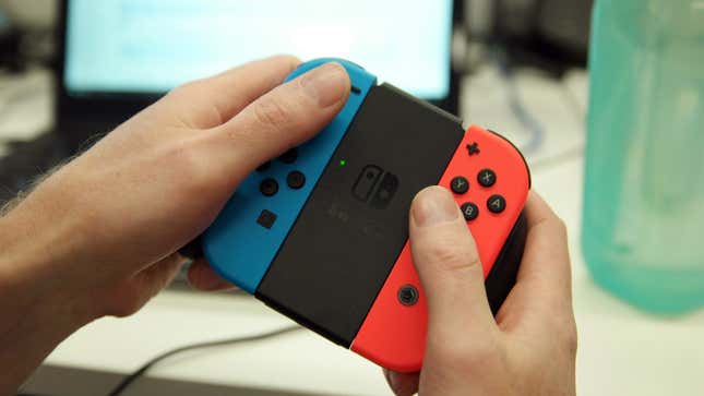 A person is holding the neon blue and red Joy-Con controller in their hands.