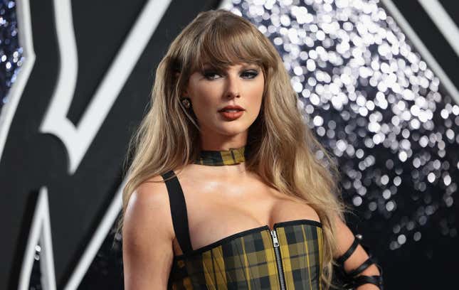 close up of Taylor Swift wearing a yellow and black plaid dress and scarf