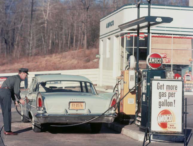 A blue Chrysler New Yorker getting gas in 1958