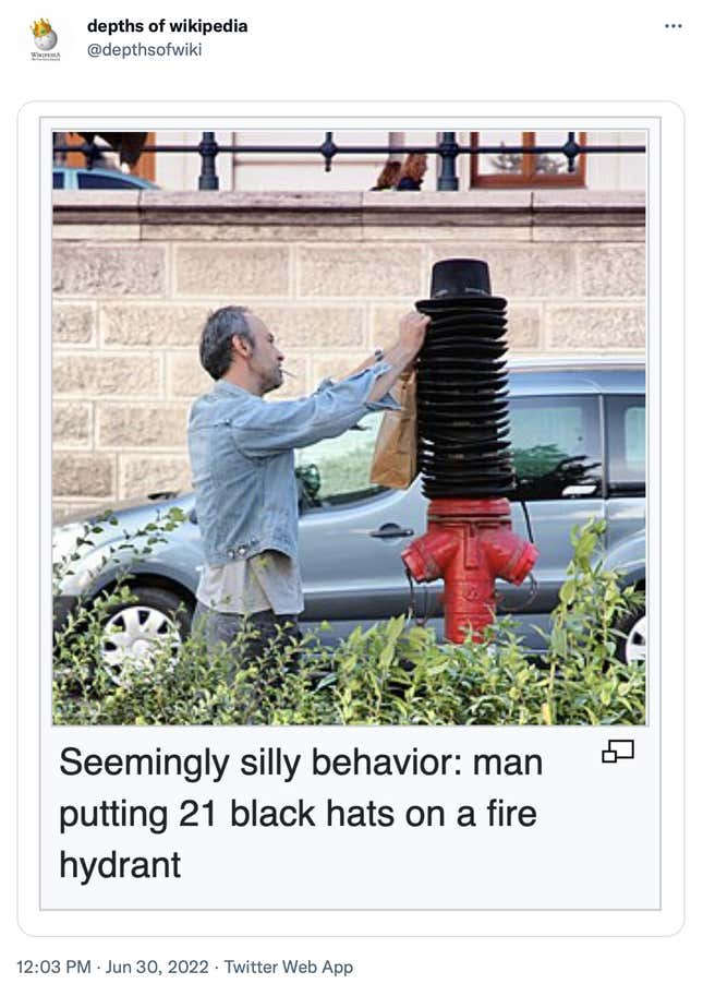 A photo of a man putting 21 hats on a fire hydrant is shown. 