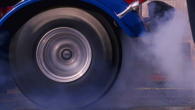 A photo of a rear wheel spinning quickly at an NHRA event in America. 