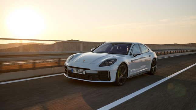 A 2024 Panamera 4S E-Hybrid sedan in white driving in front of a sunset