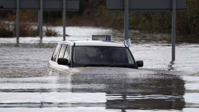 Una foto de un Range Rover conduciendo a través de una inundación. 