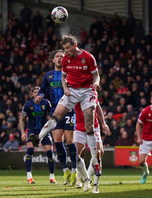 Wrexham&#39;s James McClean, top, and Mansfield Town&#39;s Will Swan challenge for the ball during the English League Two soccer match between Wrexham and Mansfield Town at the SToK Cae Ras in Wrexham, Wales, Friday, March 29, 2024. (Jacob King/PA via AP)