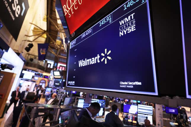 The Walmart company logo is displayed as traders work on the floor of the NYSE. 