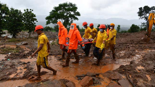 Emergency personnel carry the body of a victim at the site of a landslide at Taliye, a village in India about 110 miles (180 kilometers) southeast of Mumbai, on July 24, 2021.