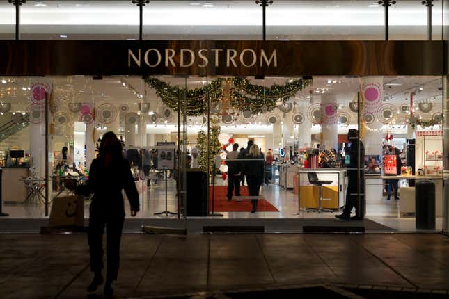 File - A security guard, right, stands at the entrance to a Nordstrom department store in Los Angeles, Dec. 2, 2021, where a smash-and-grab robbery took place. The National Retail Federation, the nation&#39;s largest retail trade group, has revised a report released in April that pulls back the claim that organized retail crime accounts for nearly half of overall industry shrink, which measures overall loss in inventory, including theft. (AP Photo/Jae C. Hong, File)