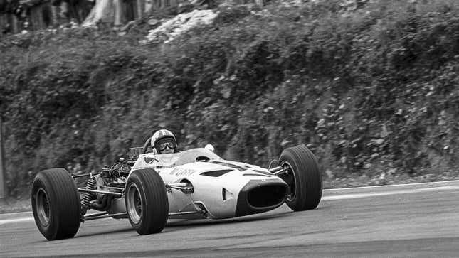 A black and white photo of a Mclaren M2B racing in Formula 1. 