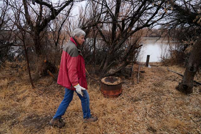 Gayna Salinas walks along her property bordering the Green River, a tributary of the Colorado River, Thursday, Jan. 25, 2024, in Green River, Utah. An Australian company and its U.S. subsidiaries are eyeing a nearby area to extract lithium, metal used in electric vehicle batteries. Salinas, whose family farms in the rural community, said she was skeptical about the project&#39;s benefits. (AP Photo/Brittany Peterson)