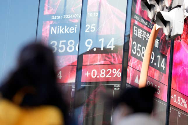 People walk in front of an electronic stock board showing Japan&#39;s Nikkei 225 index at a securities firm Monday, Jan. 15, 2024, in Tokyo. Asian markets were mostly higher on Monday, with Tokyo extending its New Year rally, as China’s central bank kept its one-year policy loan interest rate unchanged. (AP Photo/Eugene Hoshiko)