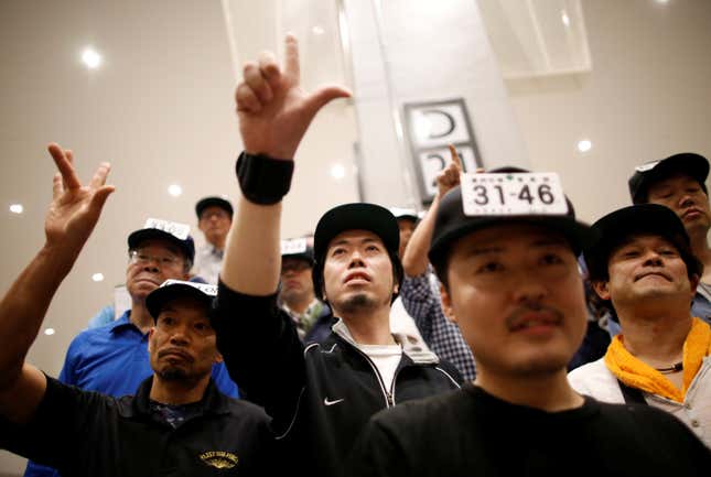 A man makes a bid at a fruit and vegetable auction.