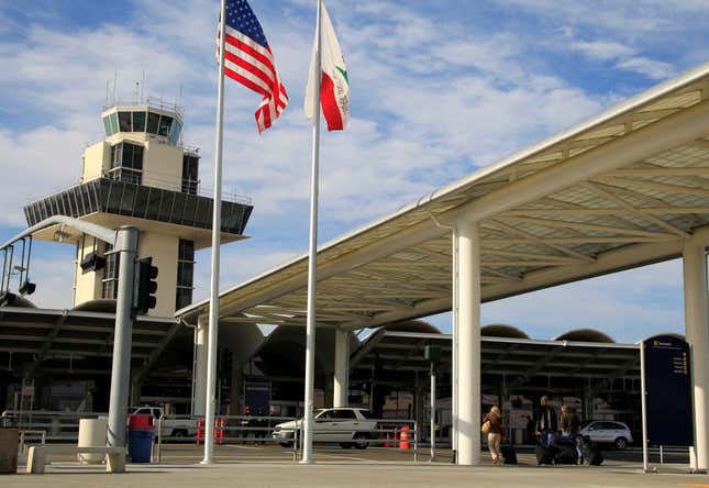 FILE - Travelers prepare to enter Oakland International airport Tuesday, Nov. 26, 2013, in Oakland, Calif. San Francisco has sued Oakland after officials there voted in favor of changing the name of the city&#39;s airport to San Francisco Bay Oakland International Airport. San Francisco officials say the change will cause confusion and is already affecting its airport financially. (AP Photo/Ben Margot, File)