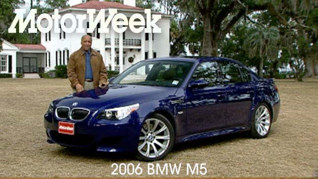 Ein Screenshot des Motorweek Retro Review des M5 von 2006, der einen blauen M5 zeigt, der auf dem Gras vor einem Haus geparkt ist.