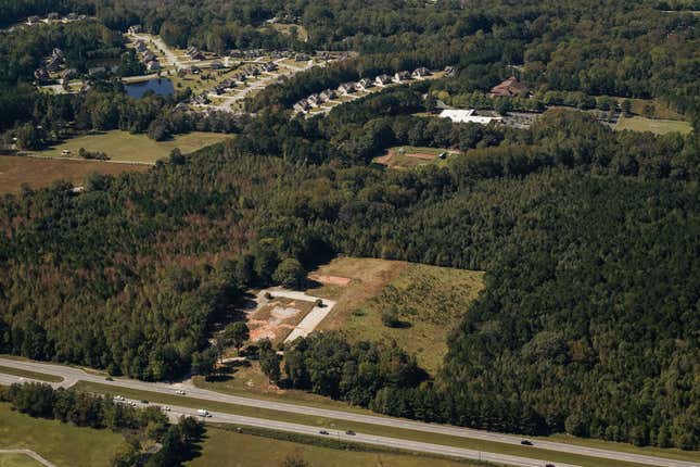 aerial view of a patch of grassy land surrounded by trees