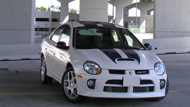 A photo of a white Dodge Neon SRT-4 with black stripes on the hood. 