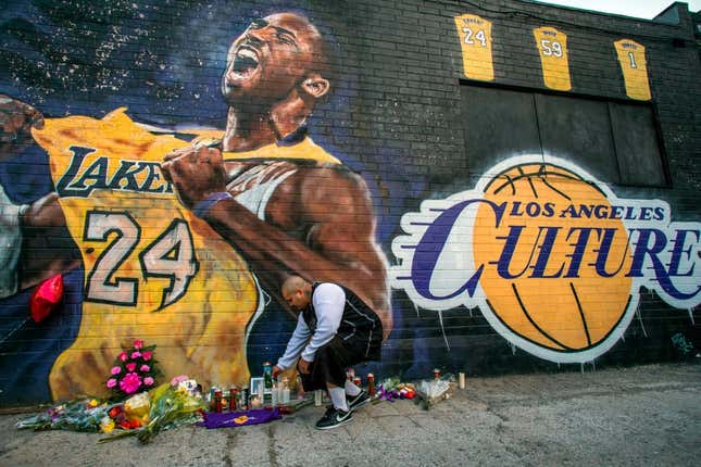 Luis Villanueva lights a candle in front of a Kobe Bryant mural in downtown Los Angeles on January 26, 2020