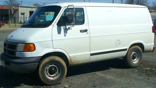 A white Dodge Cargo van with dirty tires