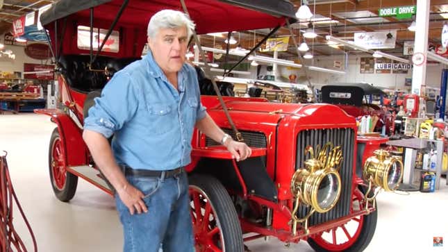 Jay Leno standing with the 1907 White Steam Car that caught fire.