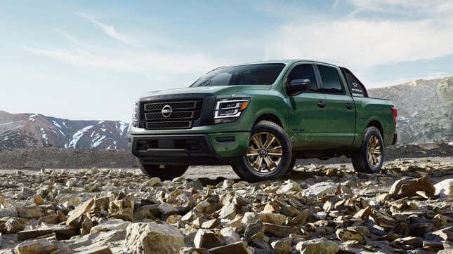 A green Nissan Titan parked on some jagged rocks