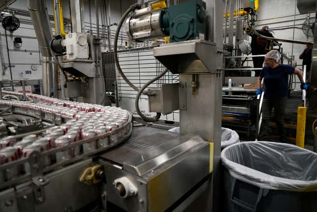 Coca-Cola cans move down a conveyer belt in the Swire Coca-Cola bottling plant Oct. 20, 2023, in Denver. Major corporations in water-guzzling industries such as apparel, food and beverage, and tech want to be better stewards of the freshwater resources they use. Coca-Cola said its water use in 2022 was about 10% more efficient compared to 2015. (AP Photo/Brittany Peterson)