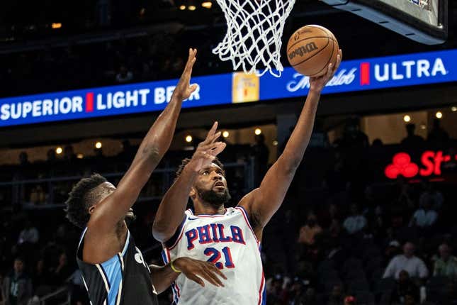 Nov 17, 2023; Atlanta, Georgia, USA; Philadelphia 76ers center Joel Embiid (21) shoots layup against Atlanta Hawks center Clint Capela (15) during the first quarter at State Farm Arena.