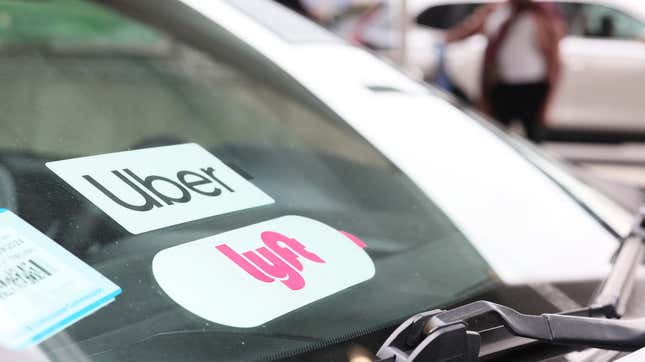 A Lyft decal is seen on a car in the pick-up area at JFK Airport on April 28, 2023 in New York City. Lyft, the ride-hailing app, confirmed that it will be laying off 1,072 employees, which equals to roughly 26% of its corporate workforce. The layoffs were announced last week but no official number was confirmed. 