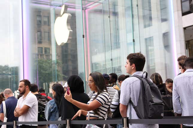 People wait in line to enter the Fifth Avenue Apple Store for new Apple products in New York City.