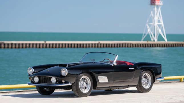 A black Ferrari convertible parked by the sea